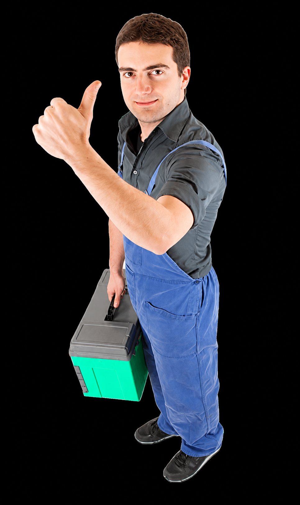 Un homme en salopette bleue et chemise grise lève le pouce en tenant une caisse à outils verte et grise.